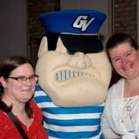 Two grads smile with Louie at Toast